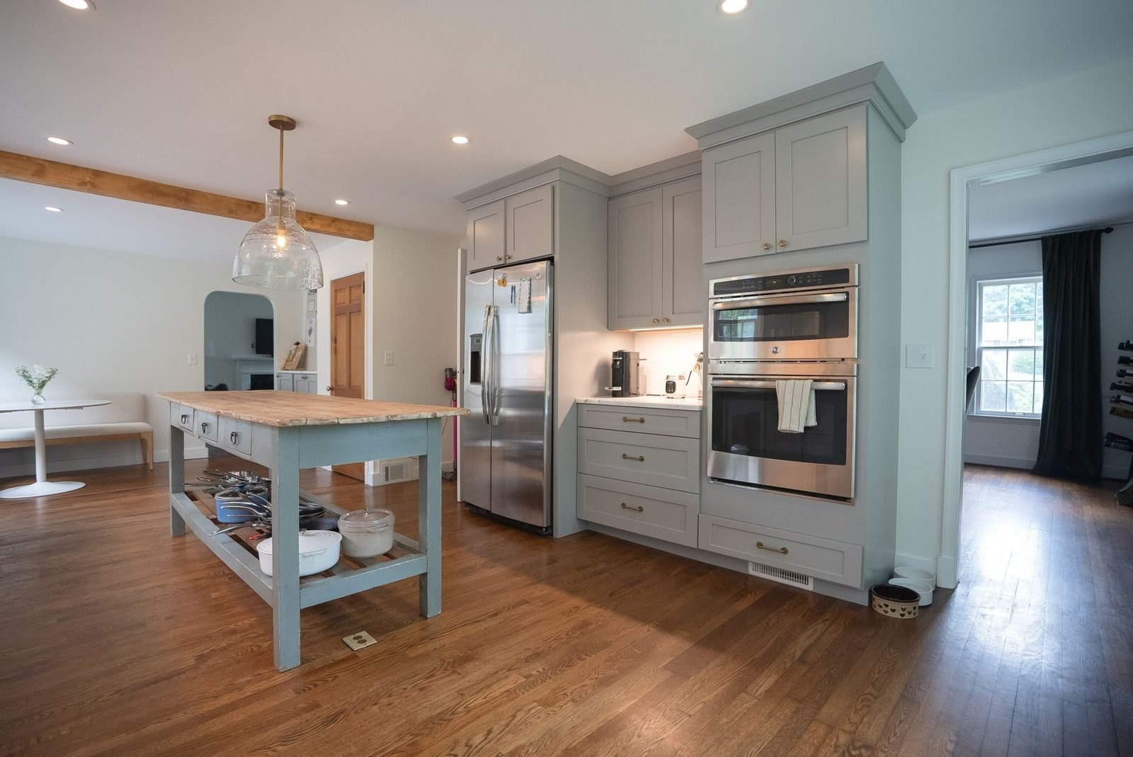 Open kitchen after: gray cabinets, a wood-topped island and hardwood floors