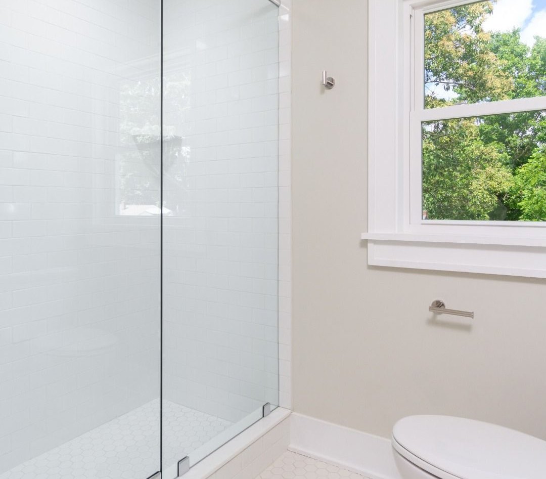Shower after: white tiled shower with a clear glass door