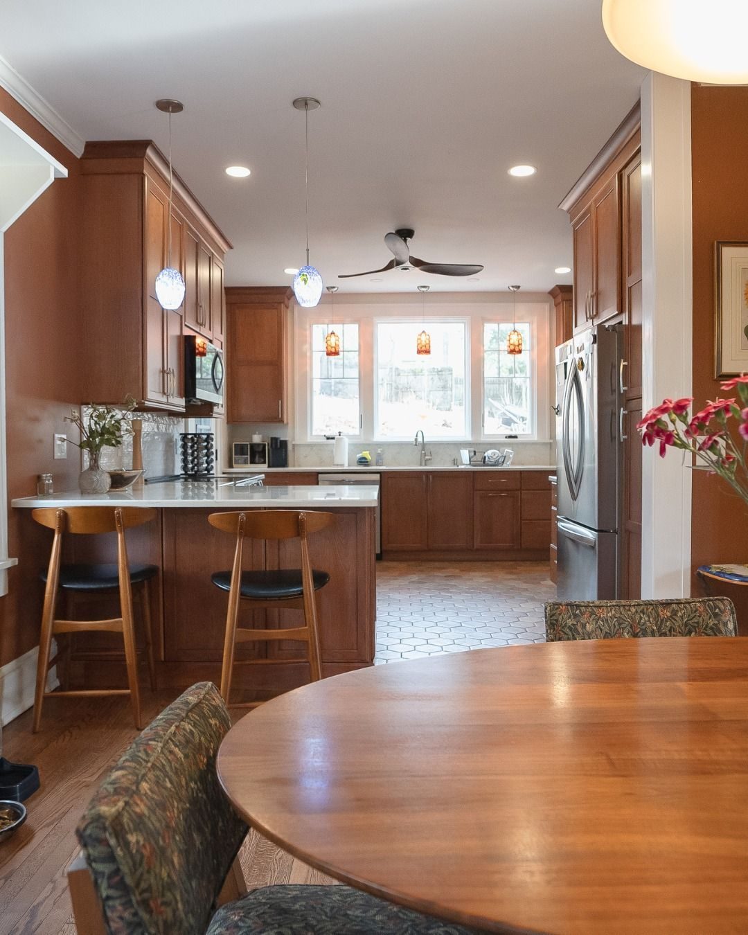 Wood-cabinet kitchen with island seating and a round dining table