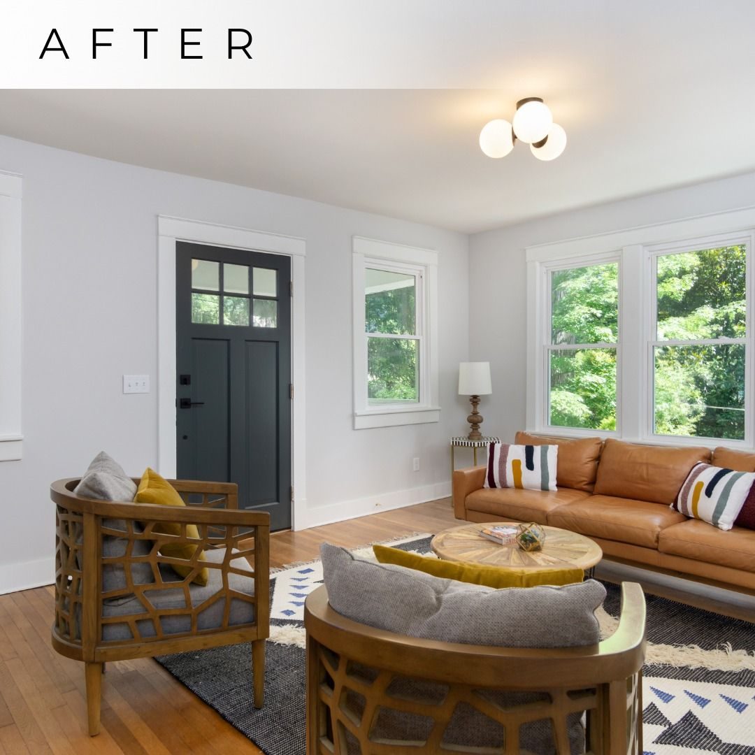 Finished living room with white walls, wood floors, a leather sofa and a dark front door