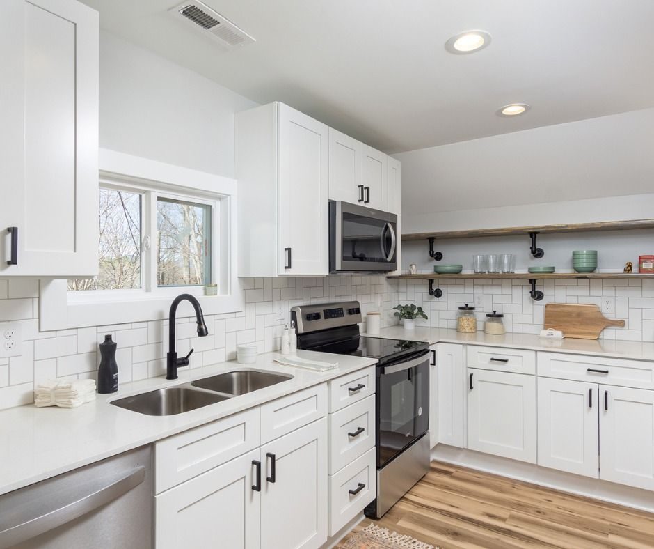 White kitchen with open shelving and stainless appliances