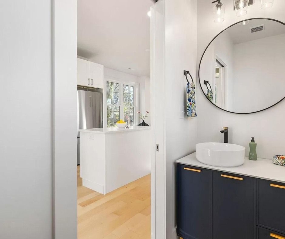 Bathroom with a vessel sink on a dark vanity and a round mirror