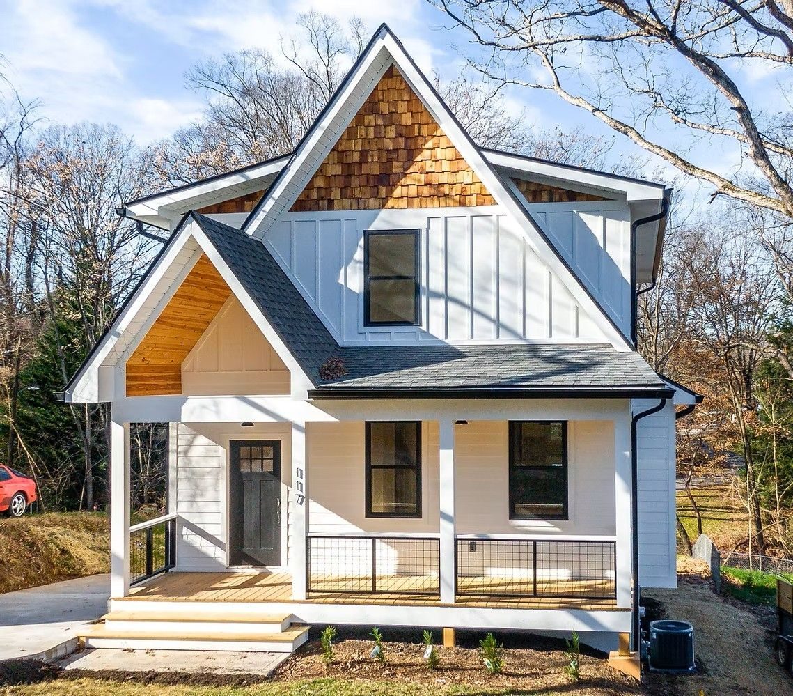 White two-story house with a cedar-shingled gable and a front porch