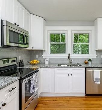 White kitchen with a stainless range and granite counters