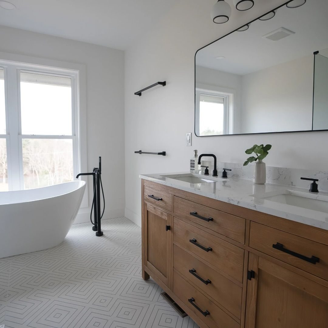 Bathroom with a freestanding tub, wood vanity and black fixtures