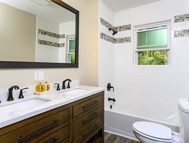 Bathroom with a wood vanity and a tiled tub surround