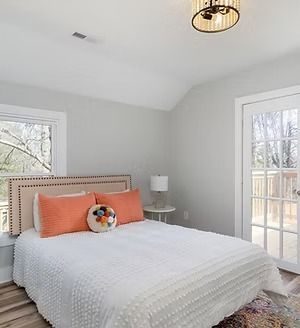 Bedroom with an upholstered headboard and orange pillows