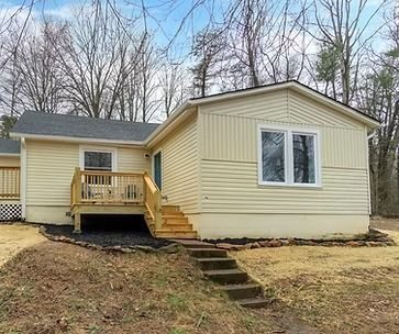 Yellow single-story house with a new deck and steps