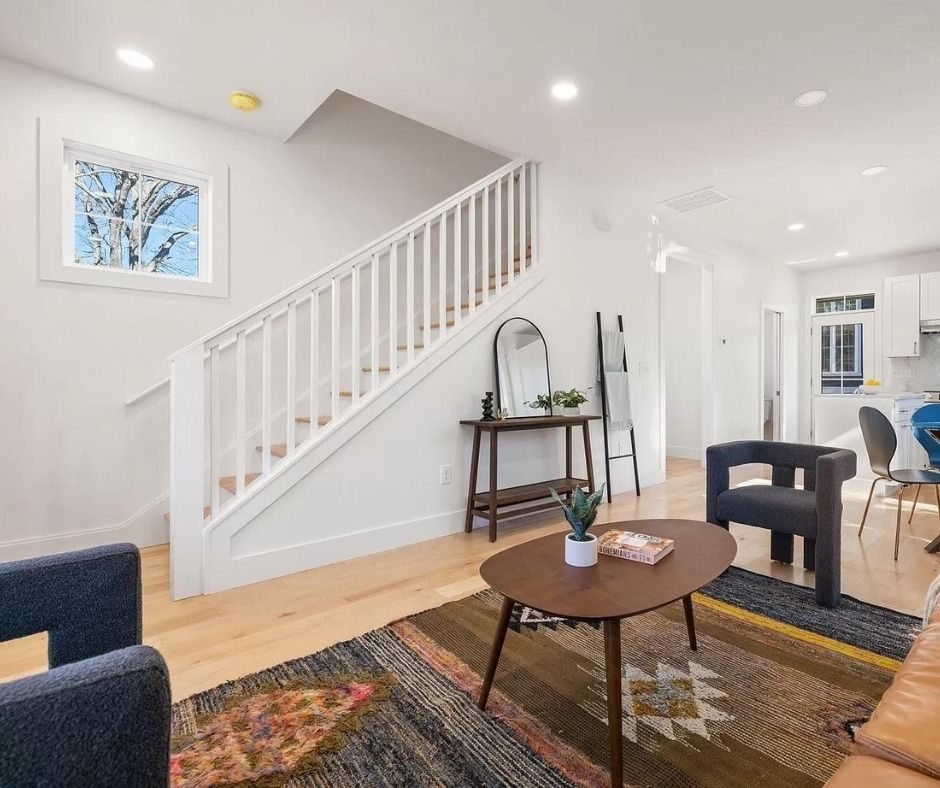 Living room with a white staircase and a round coffee table